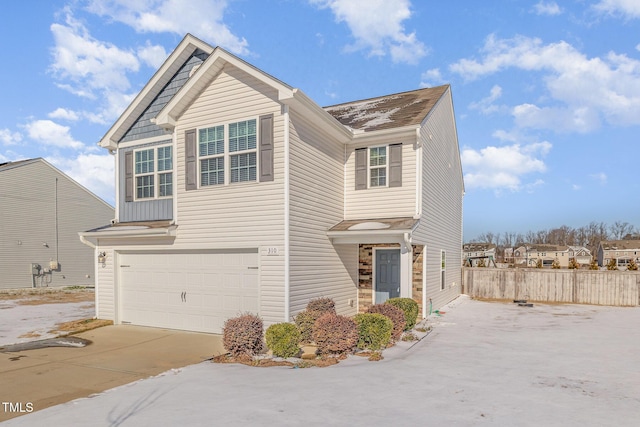 traditional home with an attached garage, board and batten siding, fence, and concrete driveway