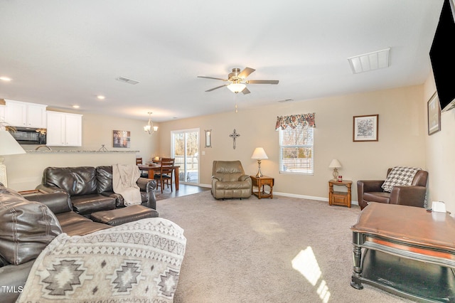 carpeted living room with a healthy amount of sunlight, ceiling fan, and visible vents