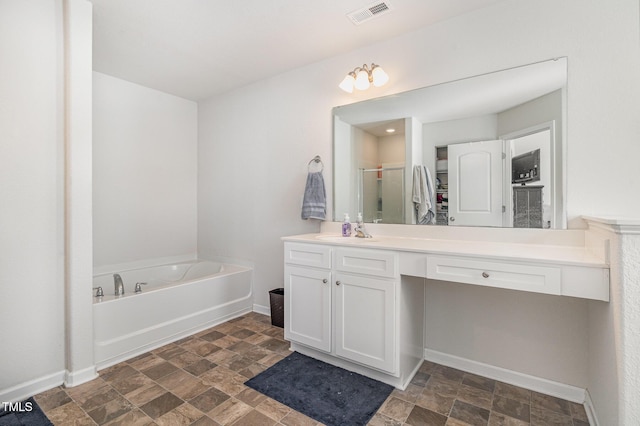 bathroom with visible vents, a stall shower, stone finish floor, vanity, and a bath