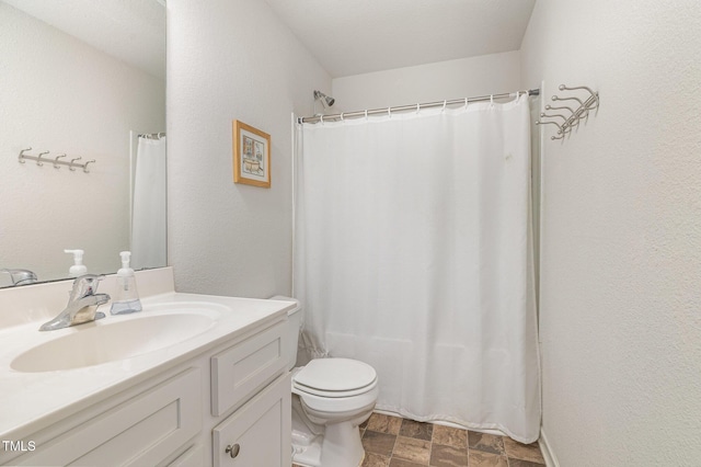 bathroom featuring shower / bathtub combination with curtain, stone finish flooring, vanity, and toilet