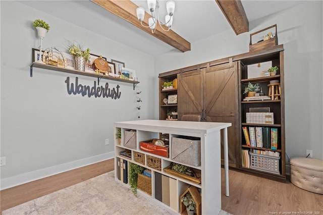 office featuring wood finished floors, a notable chandelier, beamed ceiling, and a barn door