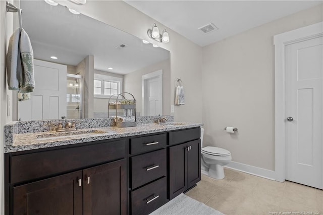 full bathroom with double vanity, baseboards, toilet, tile patterned floors, and a sink