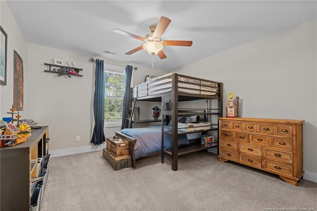 bedroom with light carpet, ceiling fan, visible vents, and baseboards