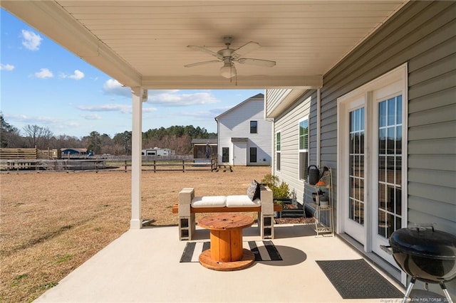 view of patio with a ceiling fan, fence, and grilling area