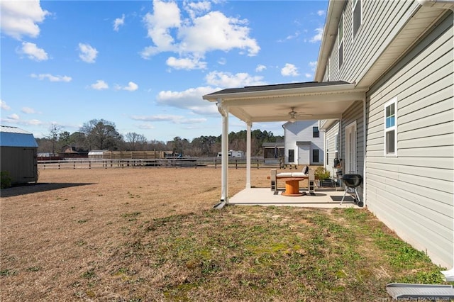 view of yard with a patio area, fence, and a ceiling fan