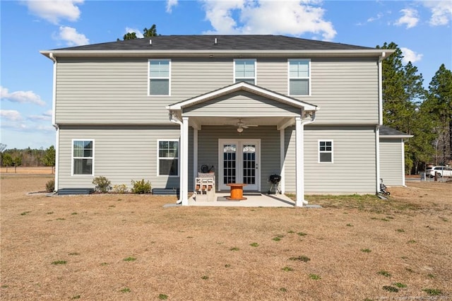 back of property with a ceiling fan, french doors, a yard, and a patio