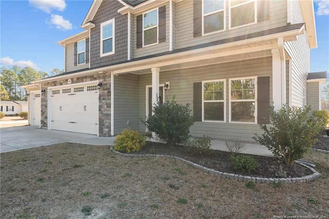 craftsman house featuring driveway, stone siding, and an attached garage