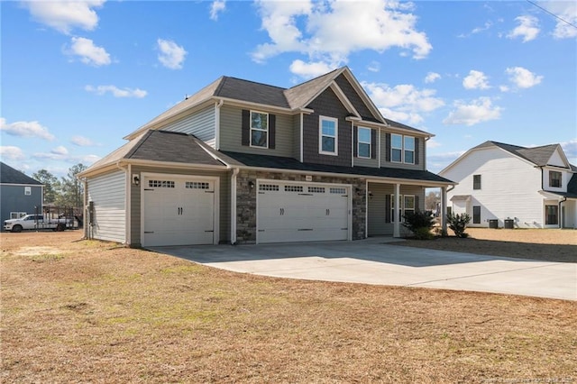 view of front of house with a front yard, stone siding, and driveway