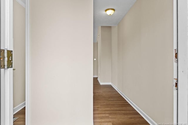 corridor with baseboards and dark wood-style flooring