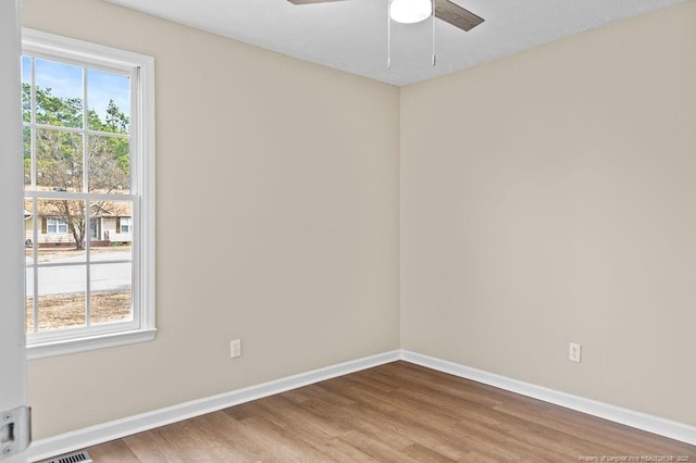 empty room with ceiling fan, baseboards, and wood finished floors