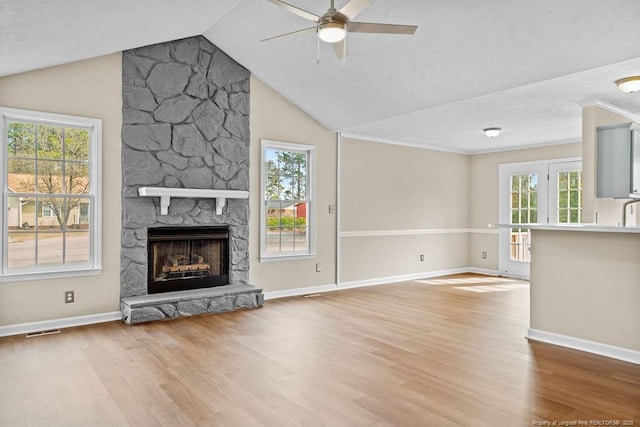 unfurnished living room featuring plenty of natural light, a fireplace, visible vents, and wood finished floors