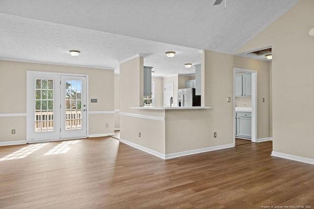 interior space featuring crown molding, a textured ceiling, baseboards, and wood finished floors