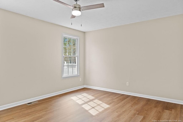 unfurnished room featuring visible vents, ceiling fan, baseboards, and wood finished floors