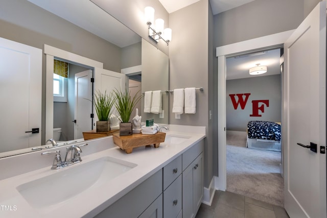 bathroom featuring double vanity, tile patterned flooring, a sink, and toilet