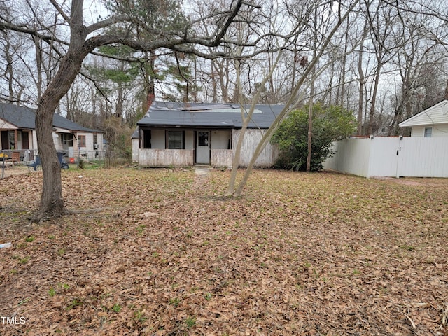 view of front of house with a chimney, fence, and a gate