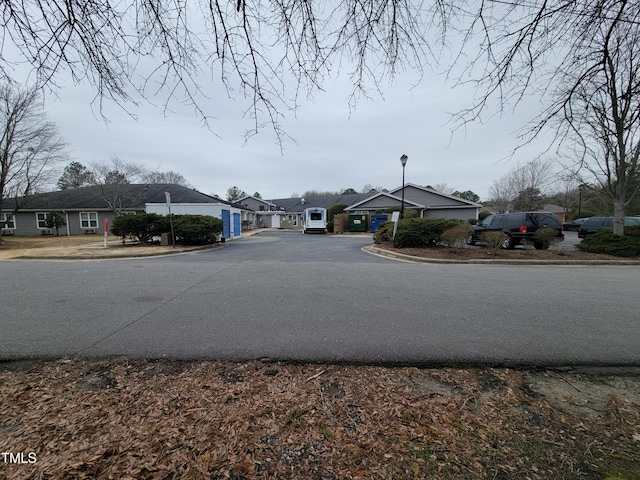 view of road with curbs, street lighting, and a residential view