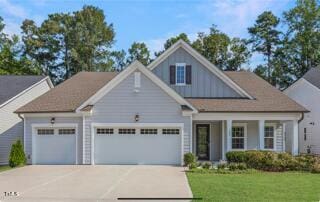 view of front of property with a garage, driveway, and a front yard