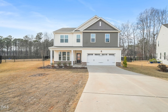 craftsman inspired home featuring driveway, an attached garage, covered porch, fence, and a front yard