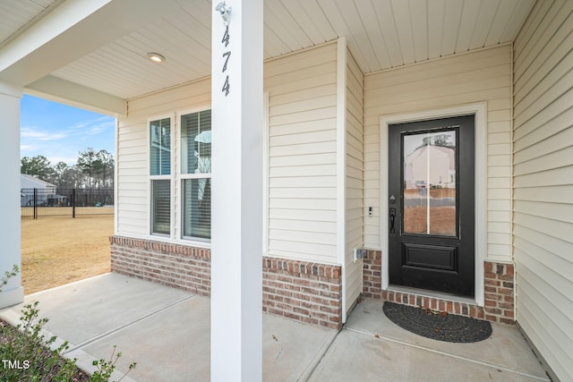 entrance to property featuring brick siding