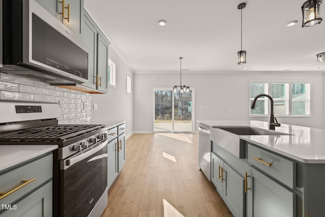 kitchen featuring appliances with stainless steel finishes, a sink, and gray cabinetry