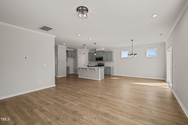 unfurnished living room featuring recessed lighting, visible vents, baseboards, light wood finished floors, and crown molding