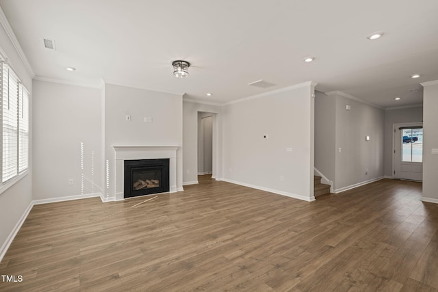 unfurnished living room featuring recessed lighting, visible vents, a glass covered fireplace, wood finished floors, and baseboards