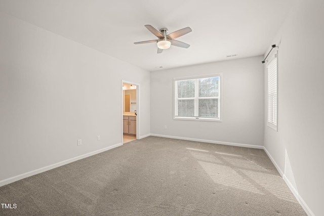 unfurnished bedroom with carpet floors, visible vents, ensuite bathroom, ceiling fan, and baseboards