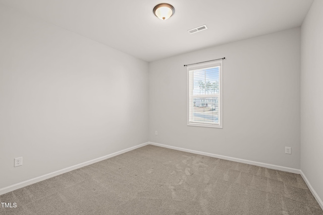 carpeted spare room featuring visible vents and baseboards