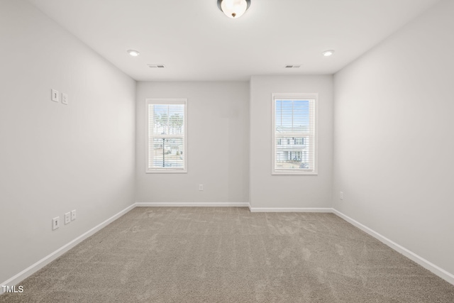 carpeted empty room with visible vents and baseboards