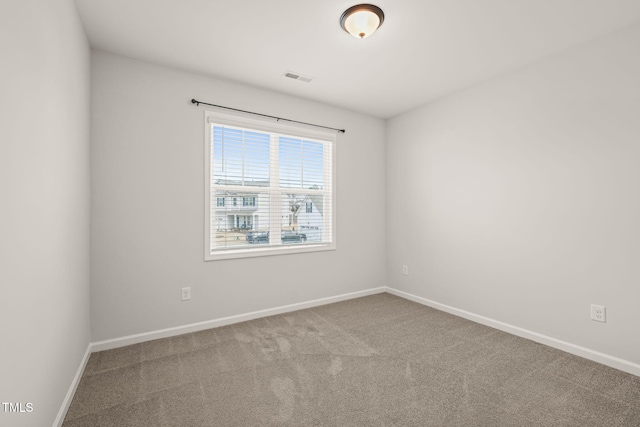 carpeted spare room with visible vents and baseboards