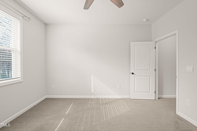 unfurnished room with a ceiling fan, carpet, and baseboards