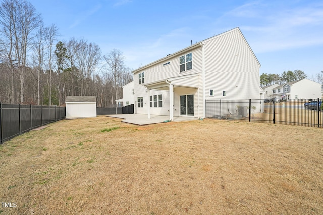 back of property with an outbuilding, a patio, a fenced backyard, a lawn, and a storage unit