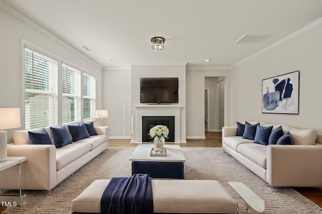 living area with ornamental molding, light wood-type flooring, a fireplace, and baseboards