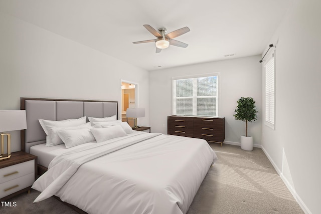 bedroom featuring ensuite bathroom, light carpet, a ceiling fan, visible vents, and baseboards