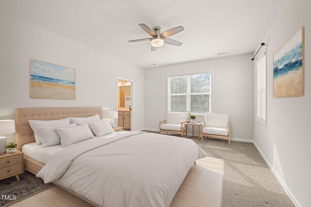 carpeted bedroom with visible vents, baseboards, ceiling fan, and ensuite bathroom