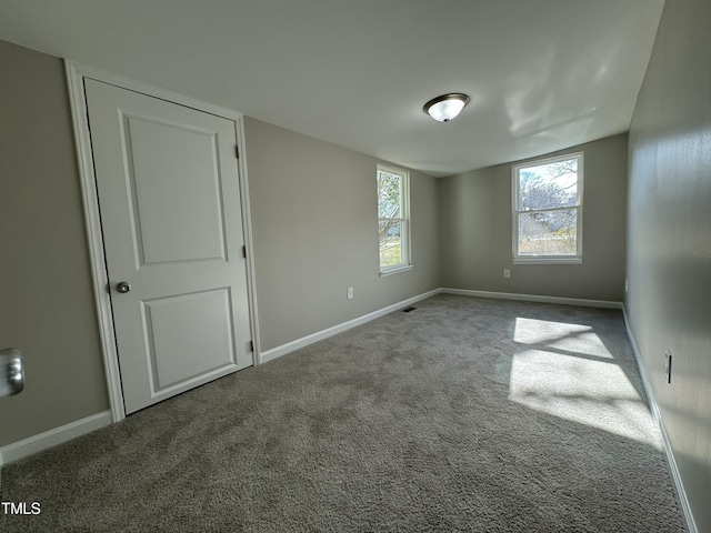 spare room featuring baseboards and carpet floors