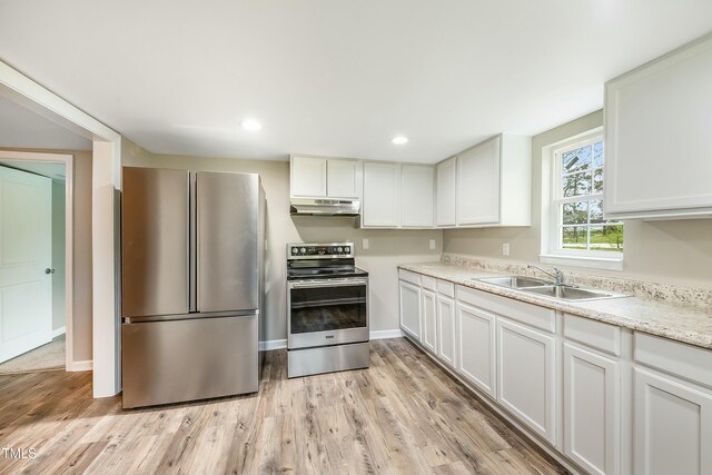 501 N 14th St, Erwin, NC 28339 - kitchen featuring under cabinet range hood, a sink, stainless steel appliances, light wood-style floors, and light countertops