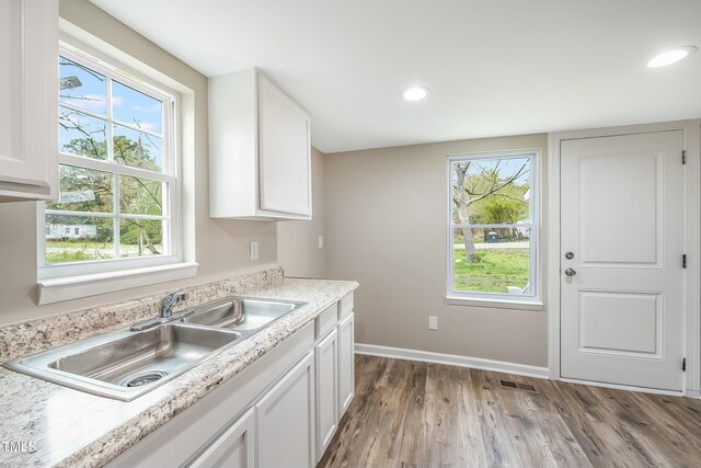 501 N 14th St, Erwin, NC 28339 - kitchen with a sink, wood finished floors, light countertops, and white cabinetry