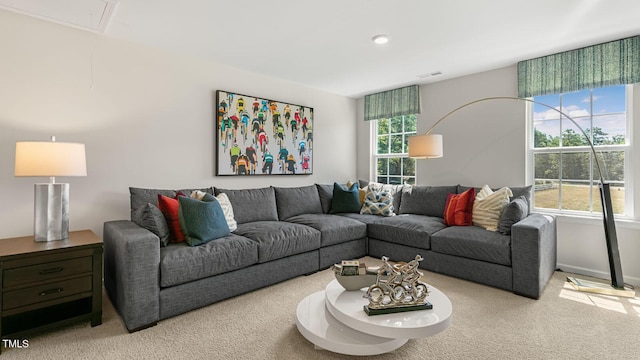 living area with a healthy amount of sunlight, carpet, attic access, and visible vents