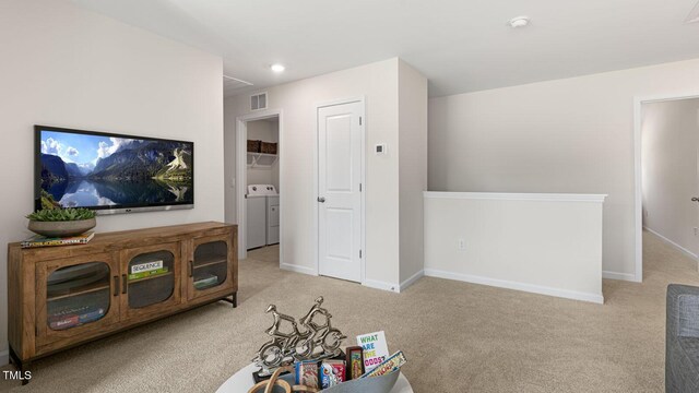 living area with washer and clothes dryer, recessed lighting, visible vents, light colored carpet, and baseboards