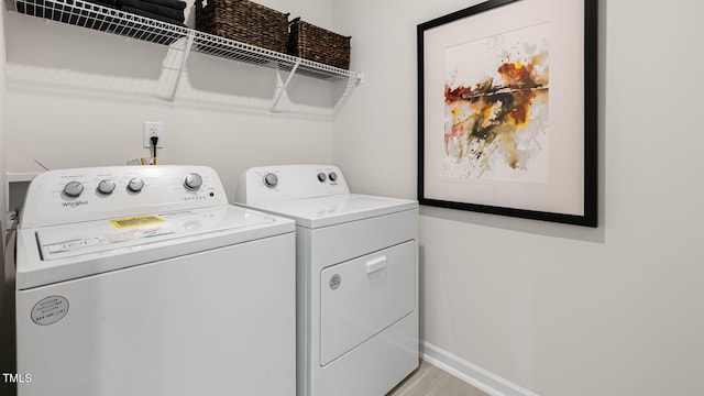 laundry room featuring laundry area, baseboards, and separate washer and dryer