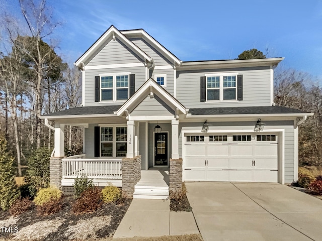 craftsman inspired home featuring an attached garage, covered porch, and concrete driveway