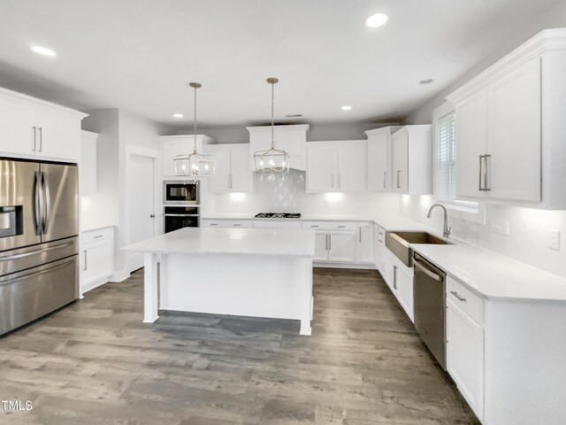 kitchen featuring tasteful backsplash, recessed lighting, a center island, appliances with stainless steel finishes, and a sink