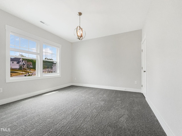 carpeted spare room with visible vents, baseboards, and an inviting chandelier