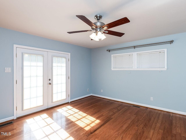 unfurnished room featuring visible vents, wood finished floors, and french doors