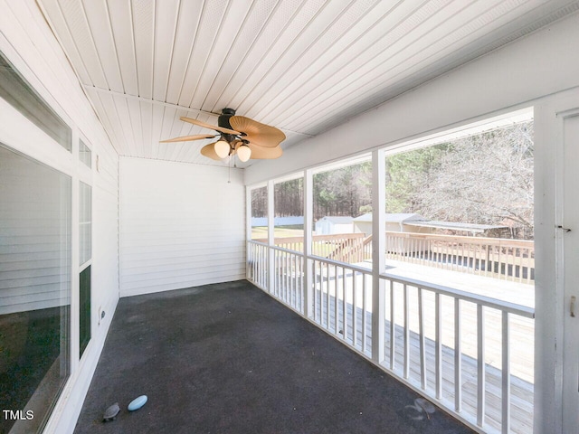 unfurnished sunroom featuring a ceiling fan