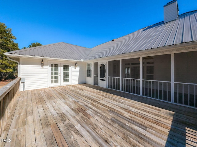 wooden deck with french doors and a sunroom