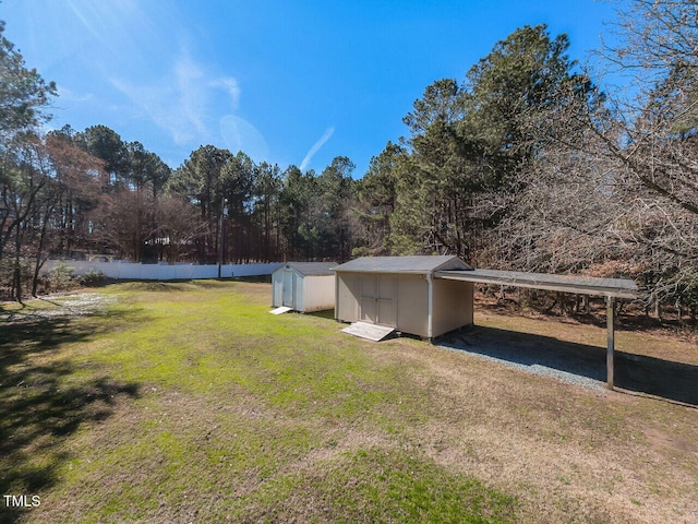 view of yard featuring an outbuilding, a carport, a shed, and fence