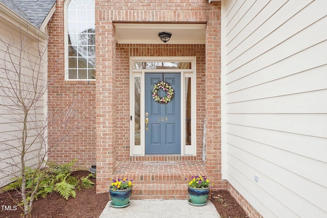 view of exterior entry with brick siding