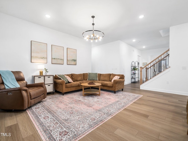 living room with baseboards, stairway, light wood-type flooring, a notable chandelier, and recessed lighting